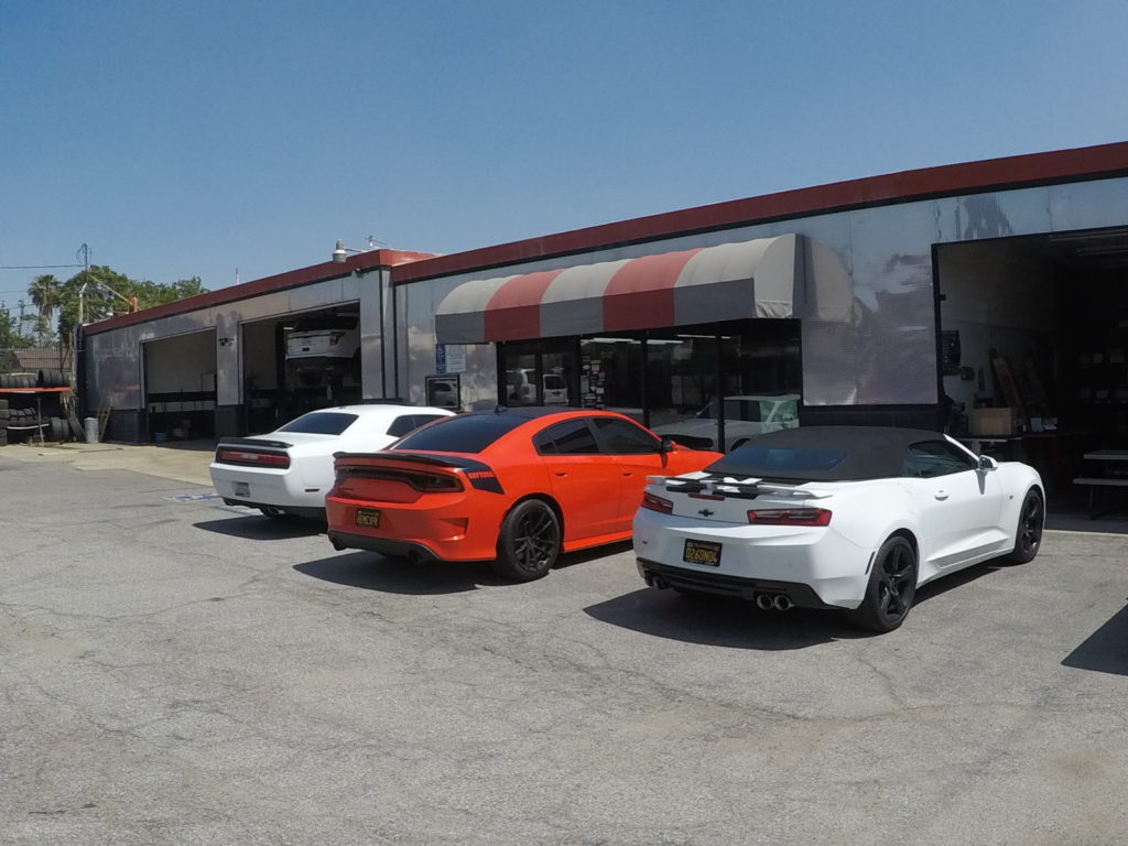 Several cars are parked in front of a large commercial building, showcasing a busy urban environment.